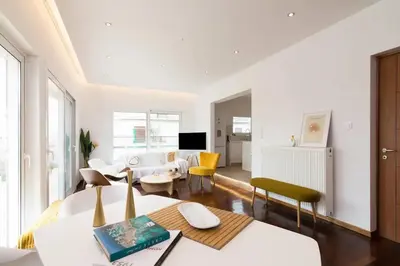 a living room with white walls and a large window at Acropolis & Lycabetus View Helios Residence in Athens