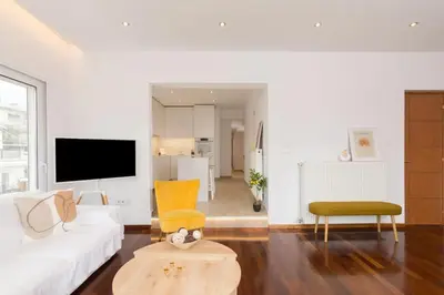 a living room with a white couch and a tv at Acropolis & Lycabetus View Helios Residence in Athens