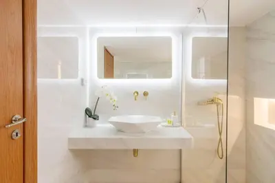 a white bathroom with a sink and a shower at Acropolis & Lycabetus View Helios Residence in Athens
