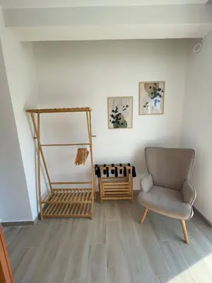 a living room with a chair and a shelf at Acropolis & Lycabetus View Helios Residence in Athens