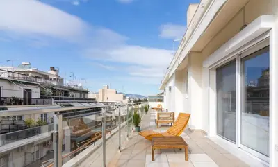a balcony with chairs and tables on a building at Acropolis & Lycabetus View Helios Residence in Athens