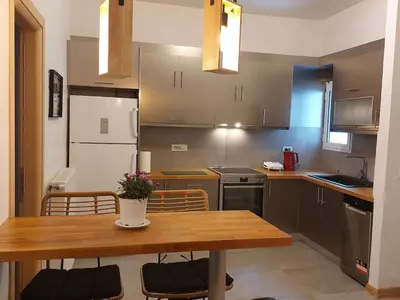 a kitchen with a wooden table and a dining room at Apartment with children's room in the city of Athens in Athens