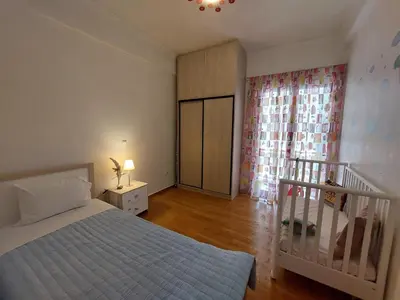 a bedroom with a bed and a crib in it at Apartment with children's room in the city of Athens in Athens