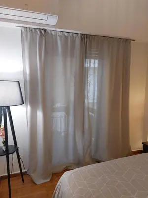 a bedroom with a bed and a white curtain at Apartment with children's room in the city of Athens in Athens