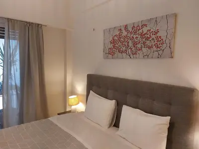 a bedroom with a bed and a painting on the wall at Apartment with children's room in the city of Athens in Athens