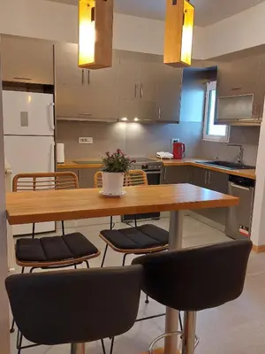 a kitchen with a wooden table and chairs at Apartment with children's room in the city of Athens in Athens