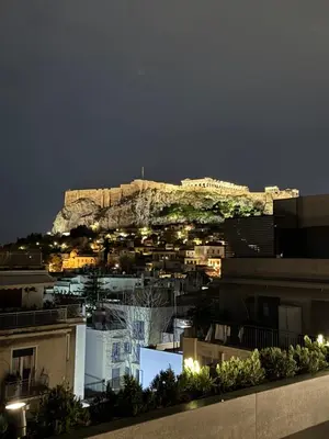a view of a city at night with the acropolis at NOOS Acropolis in Athens