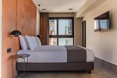 a bedroom with a large bed and a window at NOOS Acropolis in Athens
