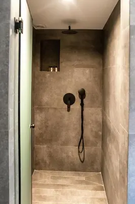a shower with a shower head on the wall at NOOS Acropolis in Athens