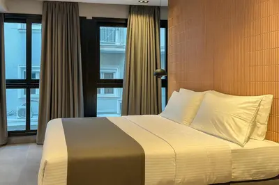a bedroom with a bed and a large window at NOOS Acropolis in Athens