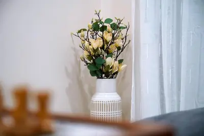 a white vase with yellow flowers in it at Aegean Modern Escape VIPGreece in Piraeus