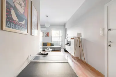 a hallway with white walls and a room with a couch at Athenian Entertainment & Relaxation Hub in Athens