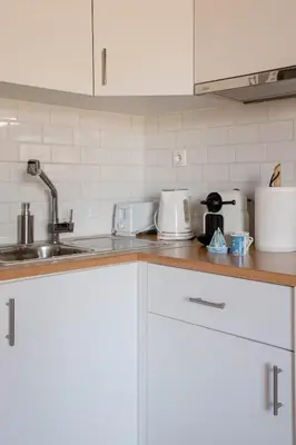 a kitchen with white cabinets and a sink at Athenian Entertainment & Relaxation Hub in Athens