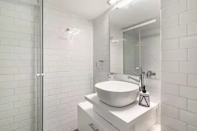 a white bathroom with a sink and a mirror at Athenian Entertainment & Relaxation Hub in Athens