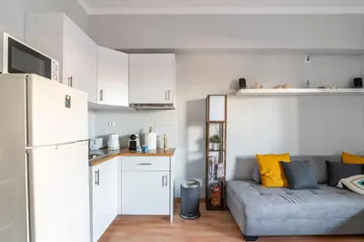a living room with a couch and a kitchen at Athenian Entertainment & Relaxation Hub in Athens