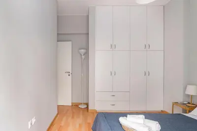 a white bedroom with a bed and white cabinets at Athenian Entertainment & Relaxation Hub in Athens