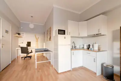 a kitchen with white cabinets and a desk in a room at Athenian Entertainment & Relaxation Hub in Athens