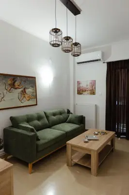 a living room with a green couch and a coffee table at Amaltheia athens in Athens