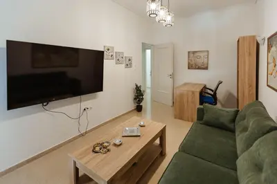 a living room with a green couch and a coffee table at Amaltheia athens in Athens
