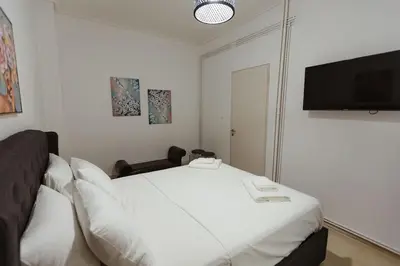 a bedroom with a bed and a flat screen tv at Amaltheia athens in Athens
