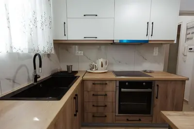 a kitchen with white cabinets and a black sink at Amaltheia athens in Athens