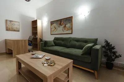 a living room with a green couch and a table at Amaltheia athens in Athens