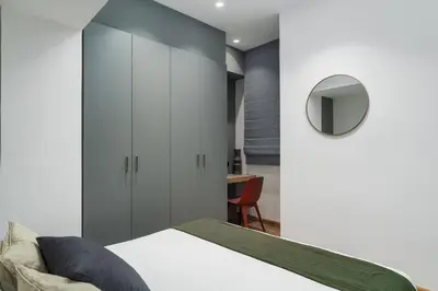 a bedroom with a bed and a mirror and a chair at Ofi the Fourth - 2-BR, Exarcheia in Athens