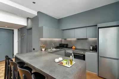 a kitchen with a large kitchen island with chairs at Ofi the Fourth - 2-BR, Exarcheia in Athens