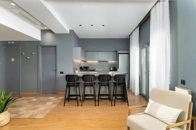 a kitchen with black stools in a room with blue walls at Ofi the Fourth - 2-BR, Exarcheia in Athens
