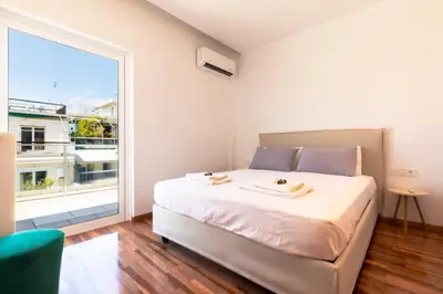 a bedroom with a large bed and a large window at Acropolis & Lycabetus View Helios Residence in Athens
