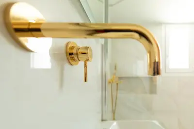 a bathroom sink with a gold faucet at Acropolis & Lycabetus View Helios Residence in Athens