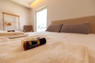 a bottle laying on a bed in a bedroom at Acropolis & Lycabetus View Helios Residence in Athens