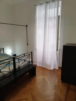 a bedroom with a bed and a window with white curtains at Golden Hotel in Athens