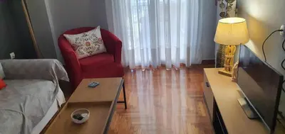 a living room with a couch and a red chair at Cozy Hideaway Near the Acropolis in Athens