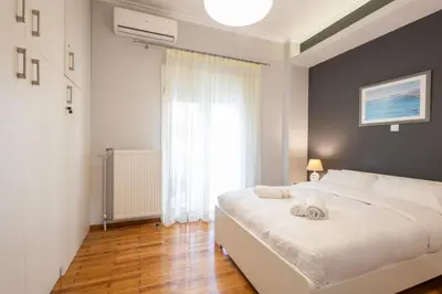 a bedroom with a large white bed and a window at Cozy Hideaway Near the Acropolis in Athens