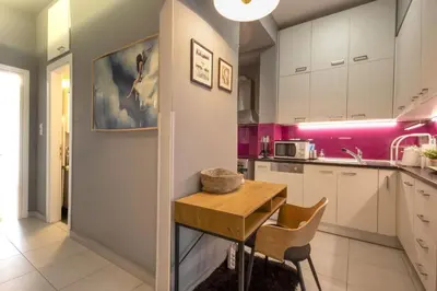 a kitchen with pink walls and a wooden table at Cozy Hideaway Near the Acropolis in Athens