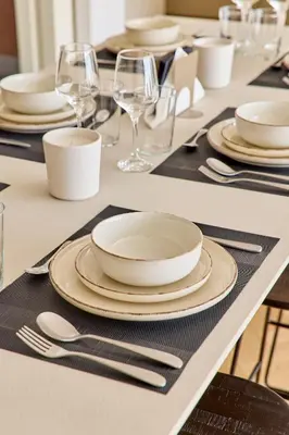 a table with white plates and silverware on it at The Samirah Luxury Residences in Elliniko in Athens