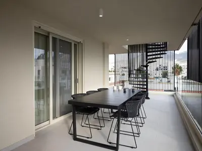 a dining room with a black table and chairs at The Samirah Luxury Residences in Elliniko in Athens