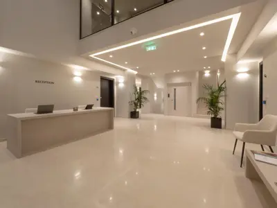an office lobby with a reception desk and chairs at The Samirah Luxury Residences in Elliniko in Athens