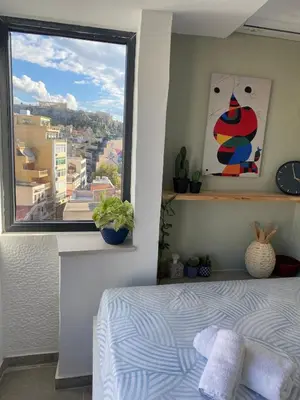 a bedroom with a bed and a large window at Mosaics Penthouse studio 360'View in Athens