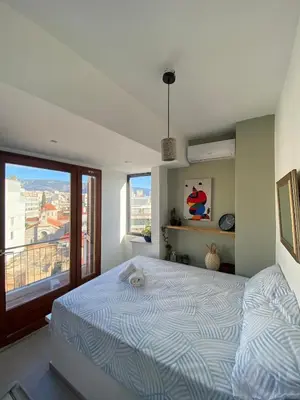 a bedroom with a bed and a large window at Mosaics Penthouse studio 360'View in Athens