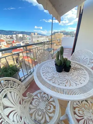 a table and chairs on a balcony with a view at Mosaics Penthouse studio 360'View in Athens