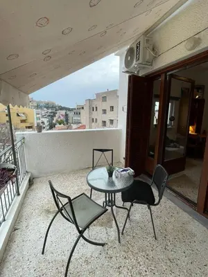 a patio with a table and chairs on a balcony at Mosaics easystay Penthouse 360'view in Athens