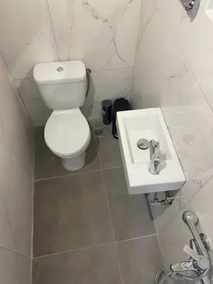 a bathroom with a white toilet and a sink at Mosaics easystay Penthouse 360'view in Athens