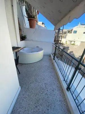 a bathroom with a tub on a balcony at Mosaics easystay Penthouse 360'view in Athens