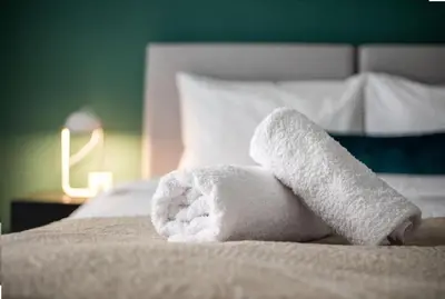 a white towel sitting on top of a bed at Urban Haven in Pagrati by MK in Athens
