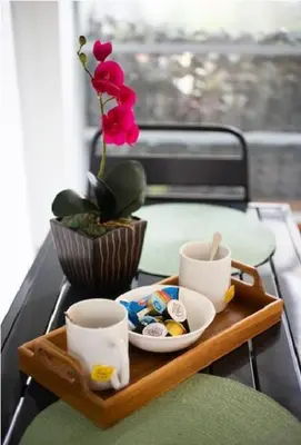 a tray with a flower and cups on a table at Urban Haven in Pagrati by MK in Athens