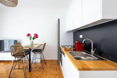 a kitchen with a sink and a table with chairs at Urban Haven in Pagrati by MK in Athens