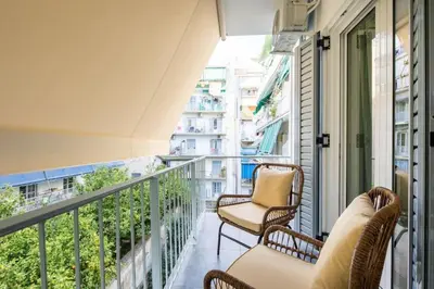 a balcony with wicker chairs and a view of a city at Urban Haven in Pagrati by MK in Athens