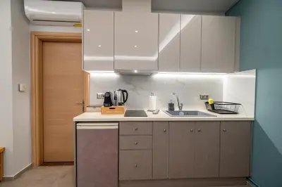 a kitchen with white cabinets and a sink at Happy apartments 0 in Athens